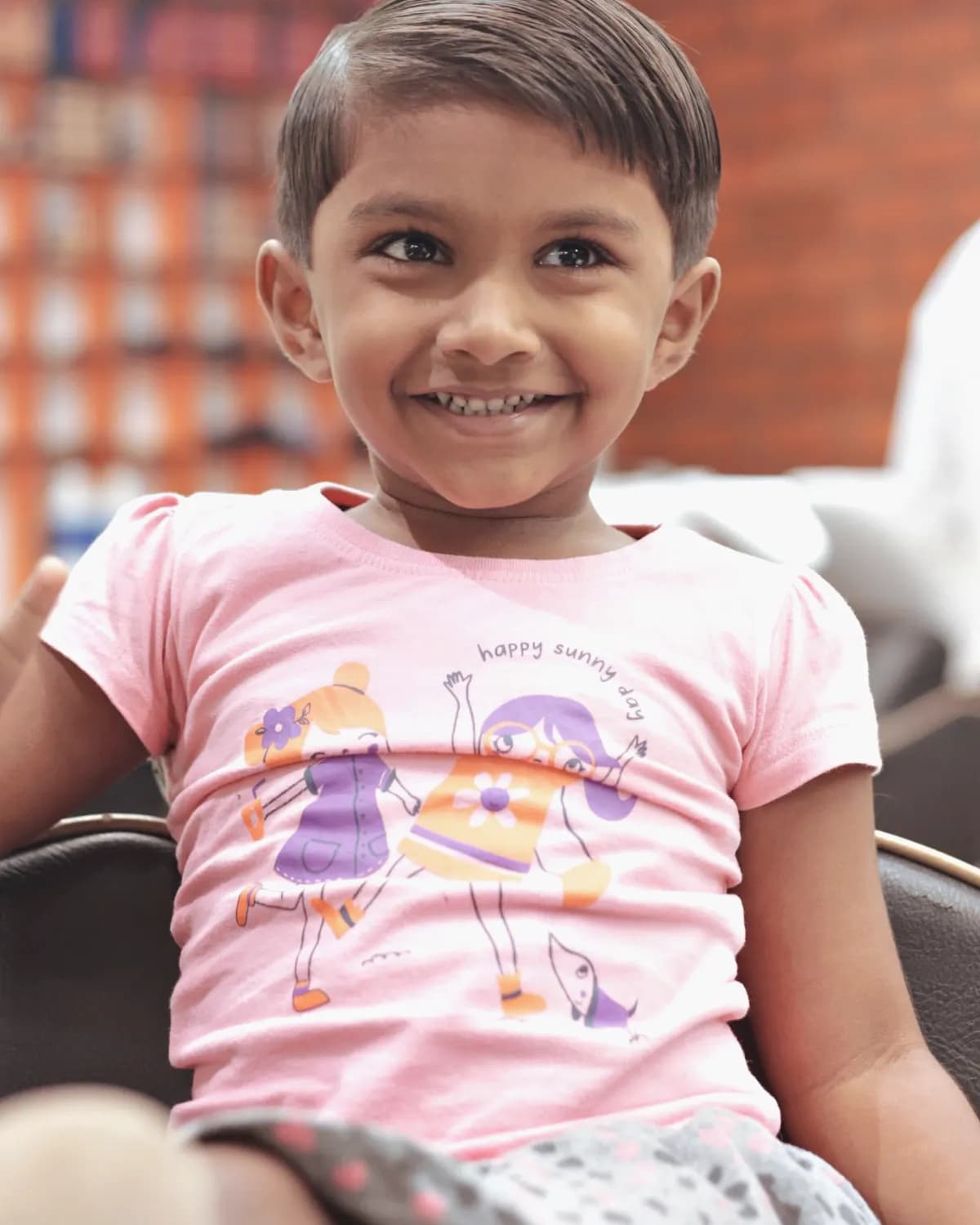 Smiling child with a fresh haircut in a salon chair