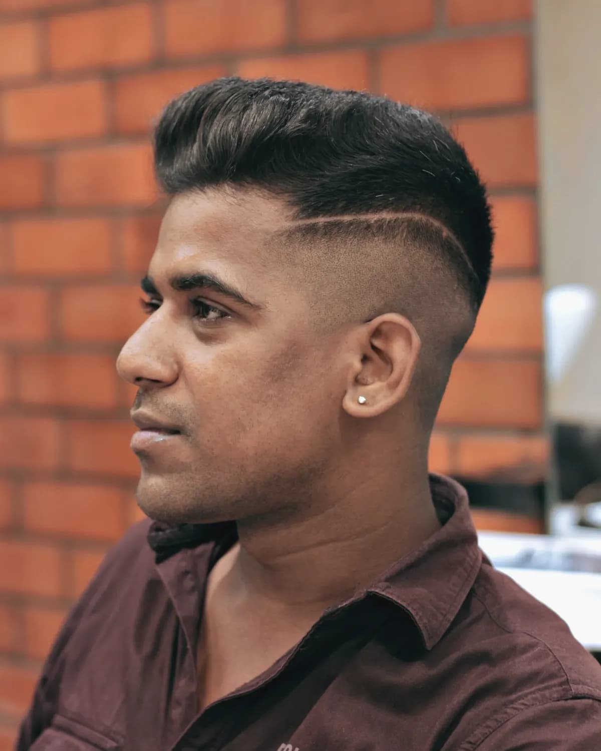 Man with a sharp skin fade and hair design in a salon